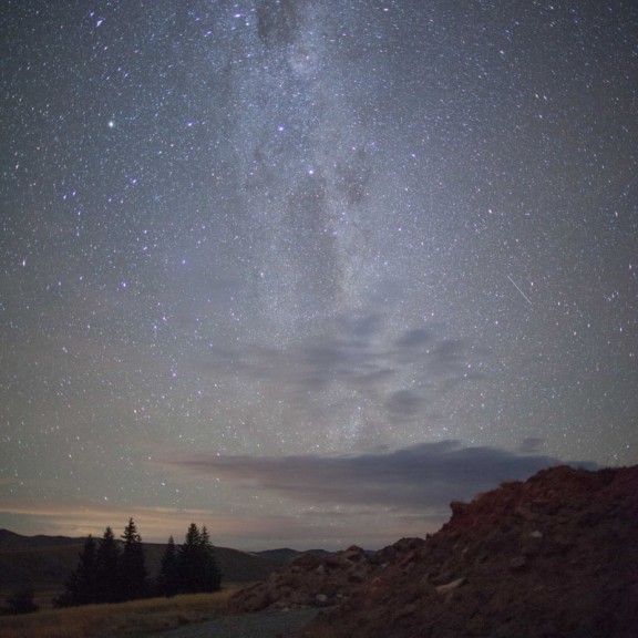 View of stoney road on edge of crater looking to milky way in night sky