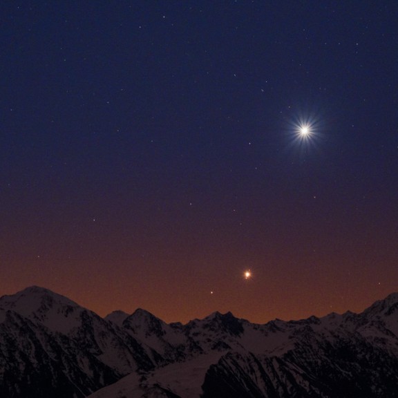 Bright planets shown in the sky above snow capped mountain